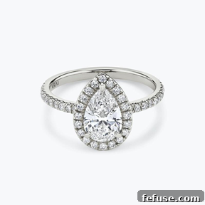 The Art of the Stack: Pairing Engagement Ring Shapes with the Perfect Wedding Band 3 The Signature Halo Ring in 18k White Gold (Featuring a Pear Cut Stone and Pavé Band)