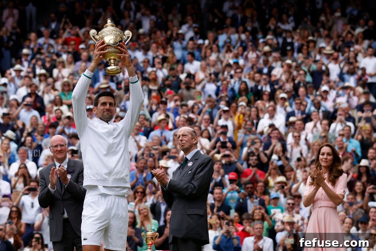 Serbia's Novak Djokovic, with Britain's Catherine (R), Duchess of Cambridge, holds the winner's trophy after beating Italy's Matteo Berrettini during their men's singles final match on the thirteenth day of the 2021 Wimbledon Championships at The All England Tennis Club in Wimbledon, southwest London, on July 11, 2021