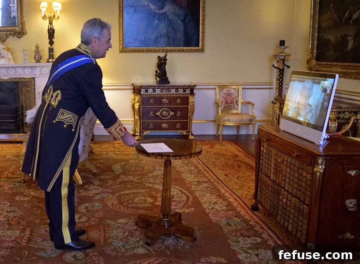 Britain's Queen Elizabeth II appears on a screen via videolink from Windsor Castle, during a virtual audience to receive Spain's Ambassador to the UK, Jose Pascual Marco Martinez, at Buckingham Palace in London on February 15, 2022