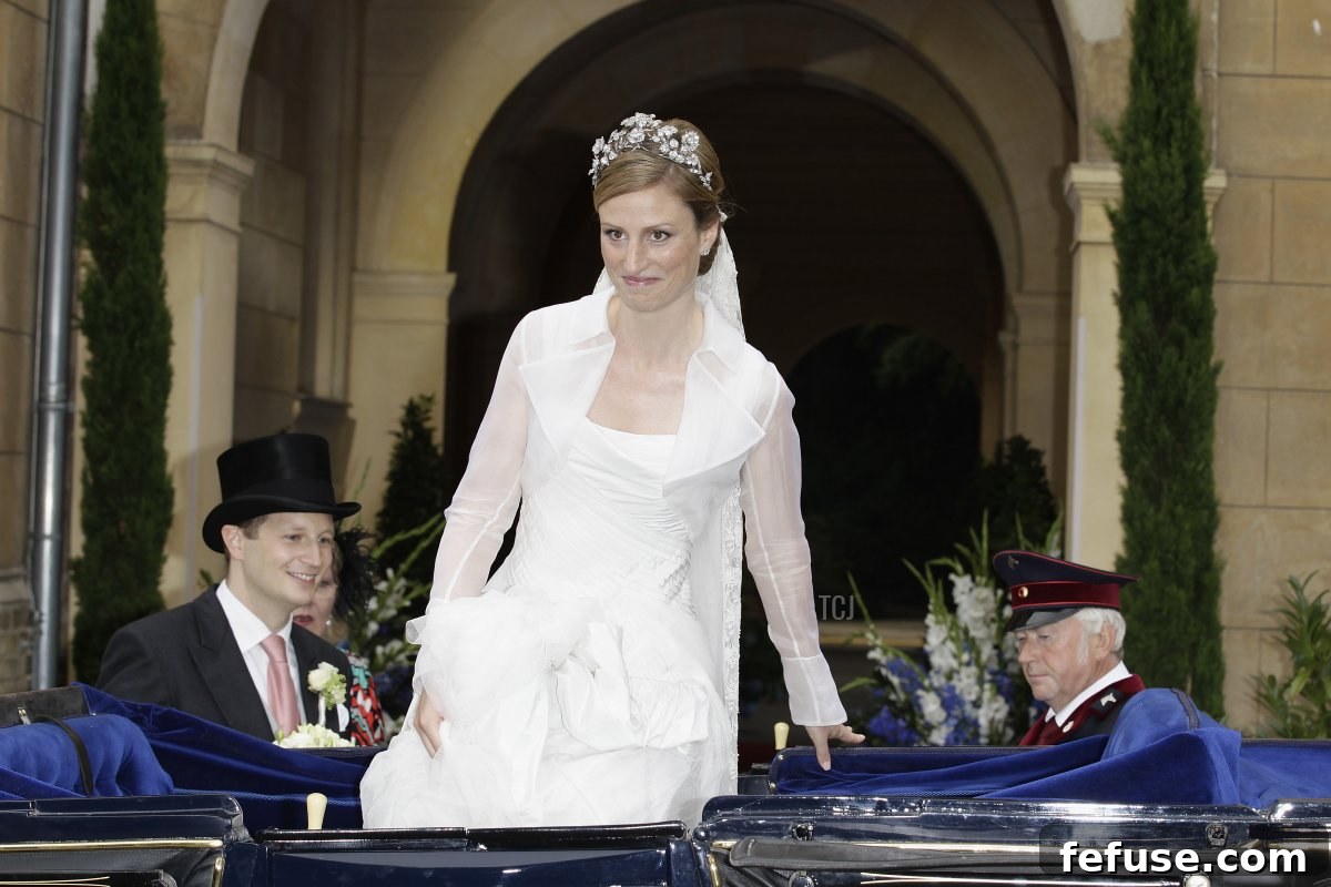 Prince Georg Friedrich of Prussia and Princess Sophie of Isenburg smiling as they ride in a historic carriage after their religious wedding ceremony in Friedenskirche Potsdam.