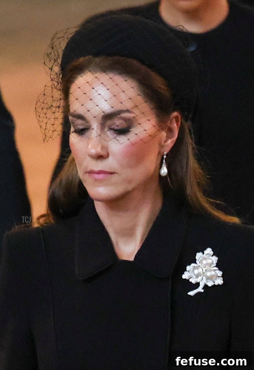 Catherine, Princess of Wales, and Meghan, Duchess of Sussex, walk in procession for the Queen's lying-in-state, with Catherine wearing a significant pearl brooch and Diana's earrings.
