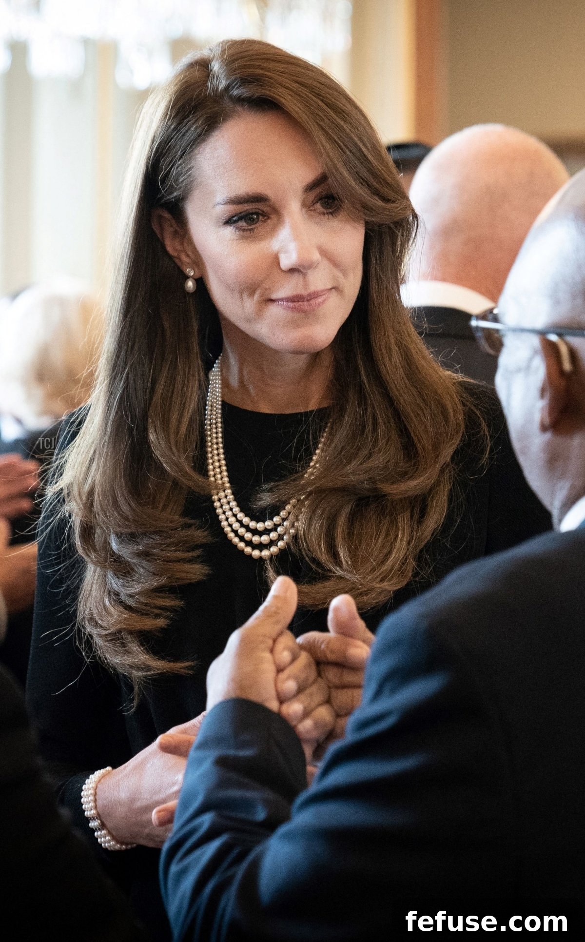 Catherine, Princess of Wales, speaks to guests at a luncheon for Commonwealth governors-general at Buckingham Palace, adorned with the Queen's pearl necklace and Diana's pearl bracelet.