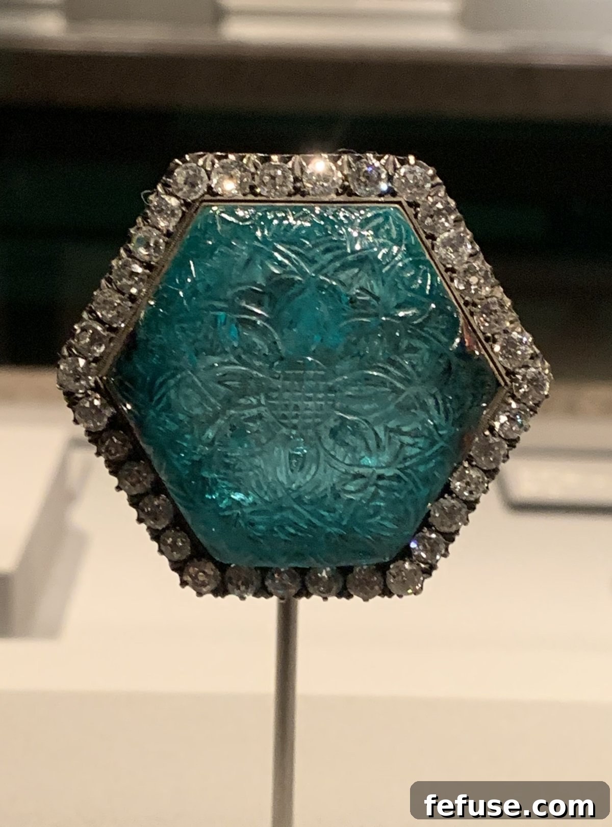 Magnificent hexagonal carved emerald with diamond surround, a prime example of exquisite Indian royal jewelry craftsmanship