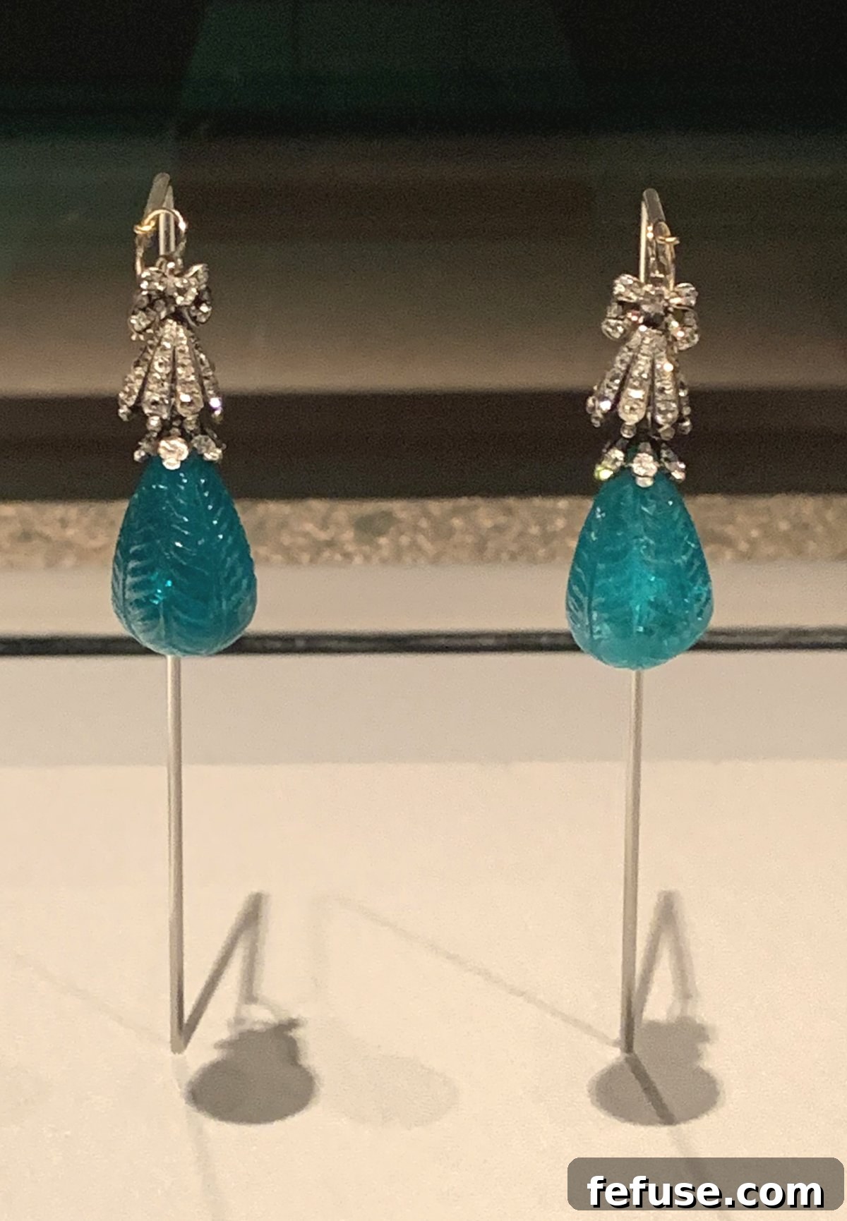 Magnificent diamond and emerald drop earrings with intricate carvings displayed in the National Museum of Qatar