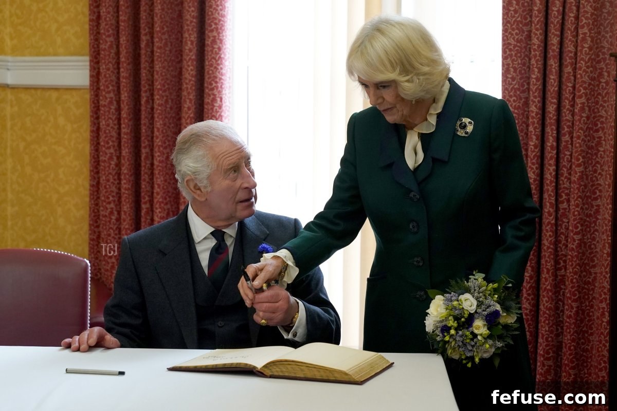 King Charles III and Camilla, Queen Consort, sign a visitor's book as they attend an official council meeting at the City Chambers in Dunfermline, Fife, to formally mark the conferral of city status on the former town on October 3, 2022 in Dunfermline, Scotland