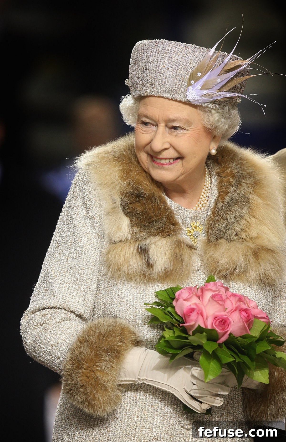 Queen Elizabeth II laughs after throwing the puck to inaugurate an ice hockey match in Bratislava, Slovakia.