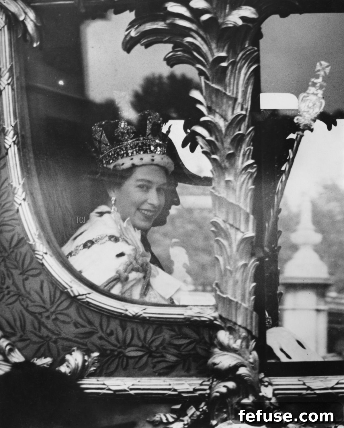 Queen Elizabeth II, wearing the Imperial State Crown, and Prince Philip waving from the Gold State Coach during their Coronation procession back to Buckingham Palace, London, June 1953. (Illustrated London News/Hulton Archive/Getty Images)
