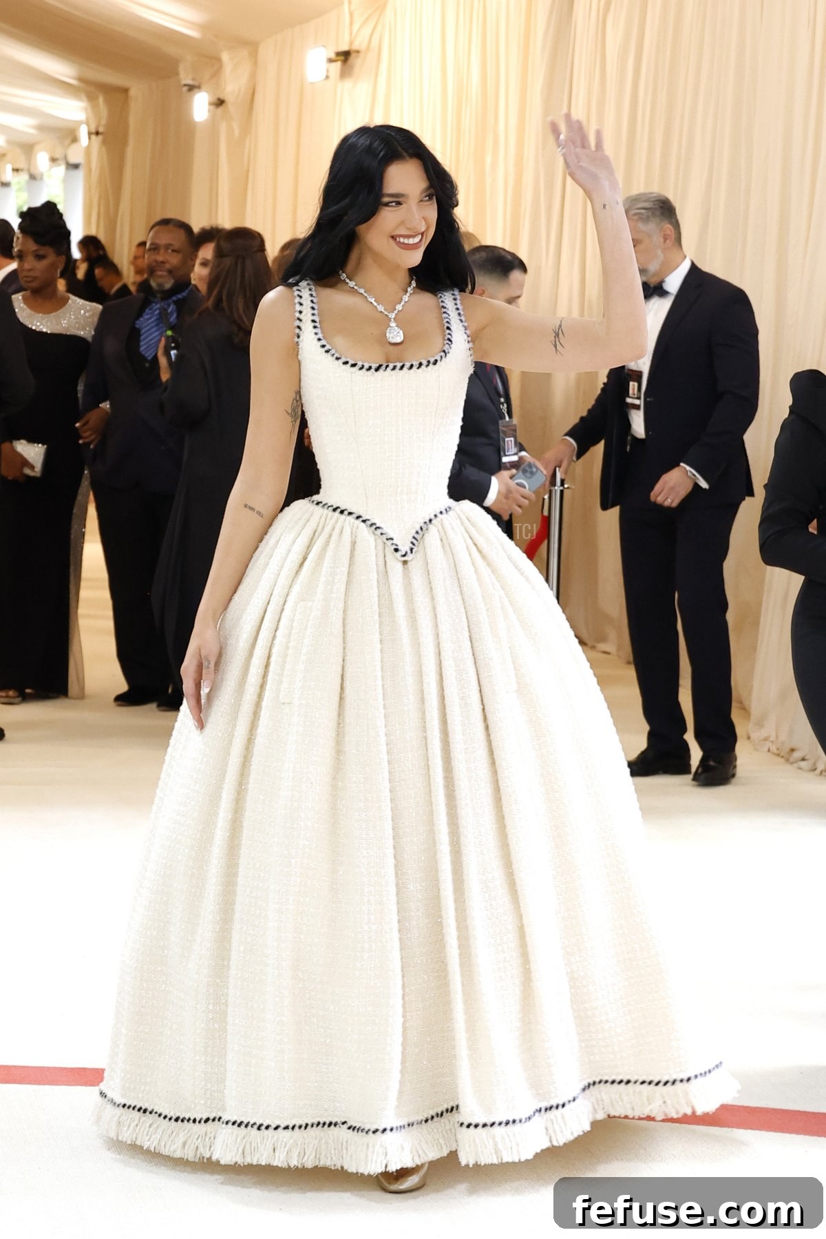 Dua Lipa embodying the 'Karl Lagerfeld: A Line of Beauty' theme at the Met Gala 2023, showcasing an elegant vintage Chanel creation.