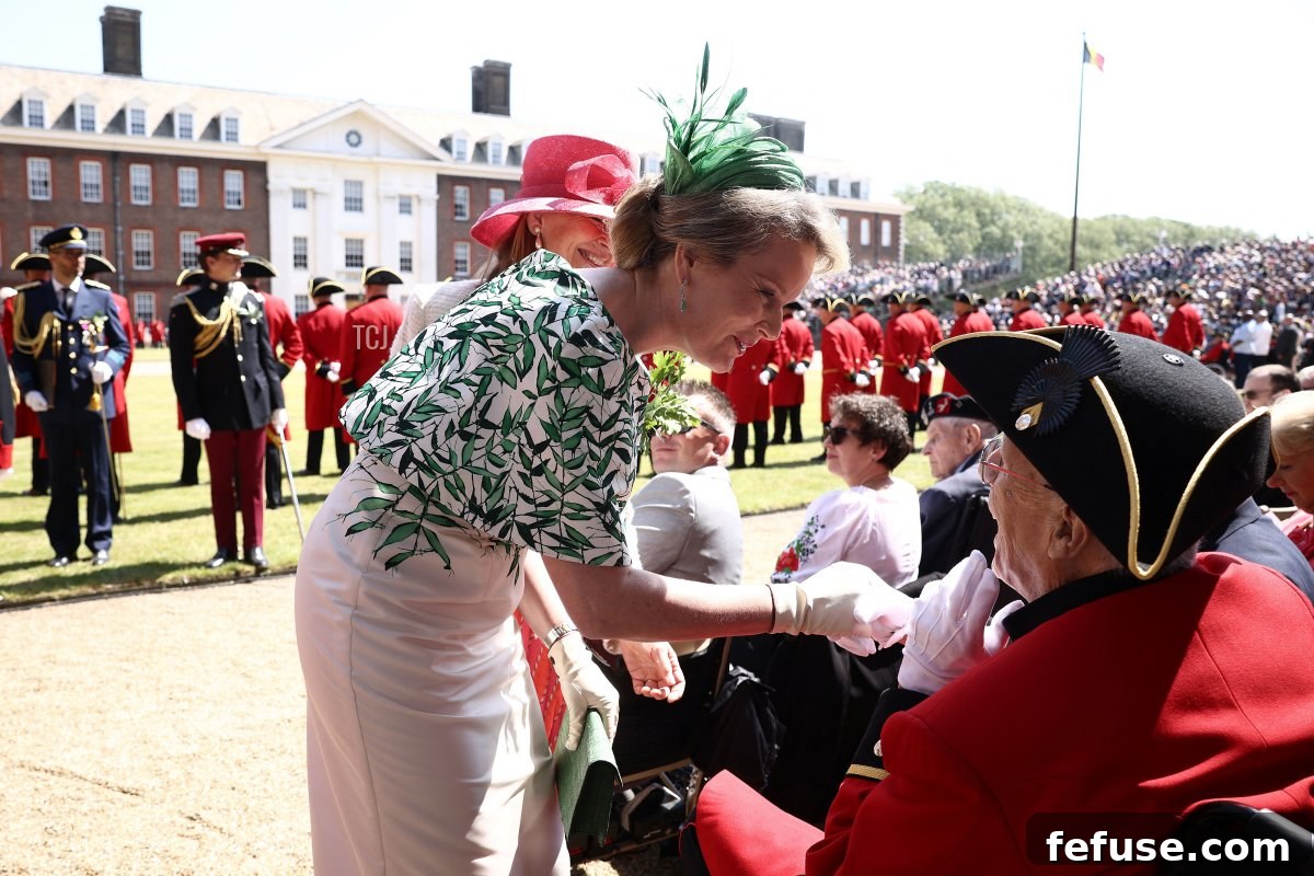 Queen Mathilde of the Belgians greets a Chelsea Pensioner during the Founder's Day Parade. (HENRY NICHOLLS/AFP via Getty Images)