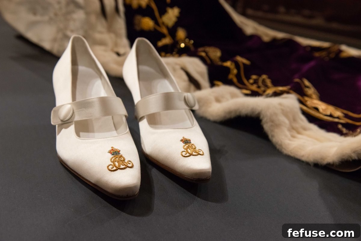 Queen Camilla's custom-made coronation shoes, intricately embroidered with her royal cypher, exhibited at Buckingham Palace in July 2023. (Royal Collection Trust)