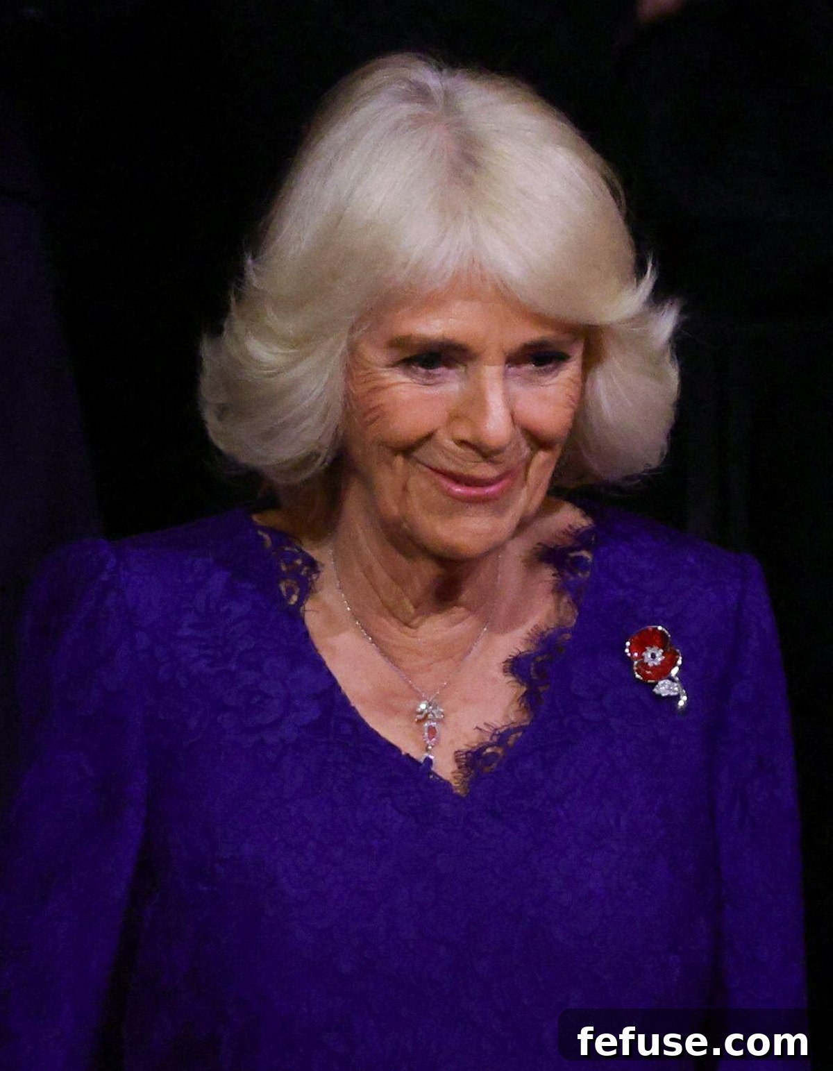 Regal Pink Topaz and Sapphire Pendant for Queen Camilla 8 Close-up of Queen Camilla wearing an exquisite diamond ribbon pendant necklace with pink topaz and blue sapphire clusters, believed to be from Queen Elizabeth II's collection.