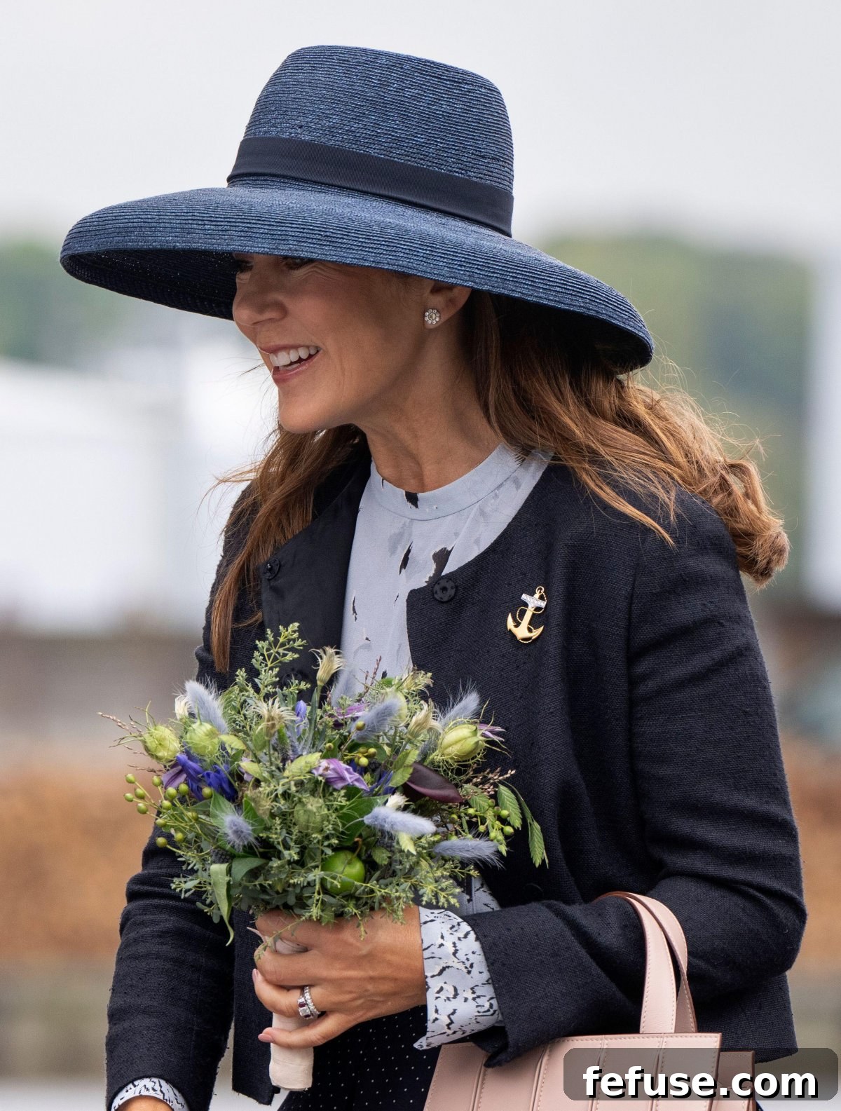 Queen Mary of Denmark showcasing her elegant anchor brooch and floral earrings during her visit to Velje.