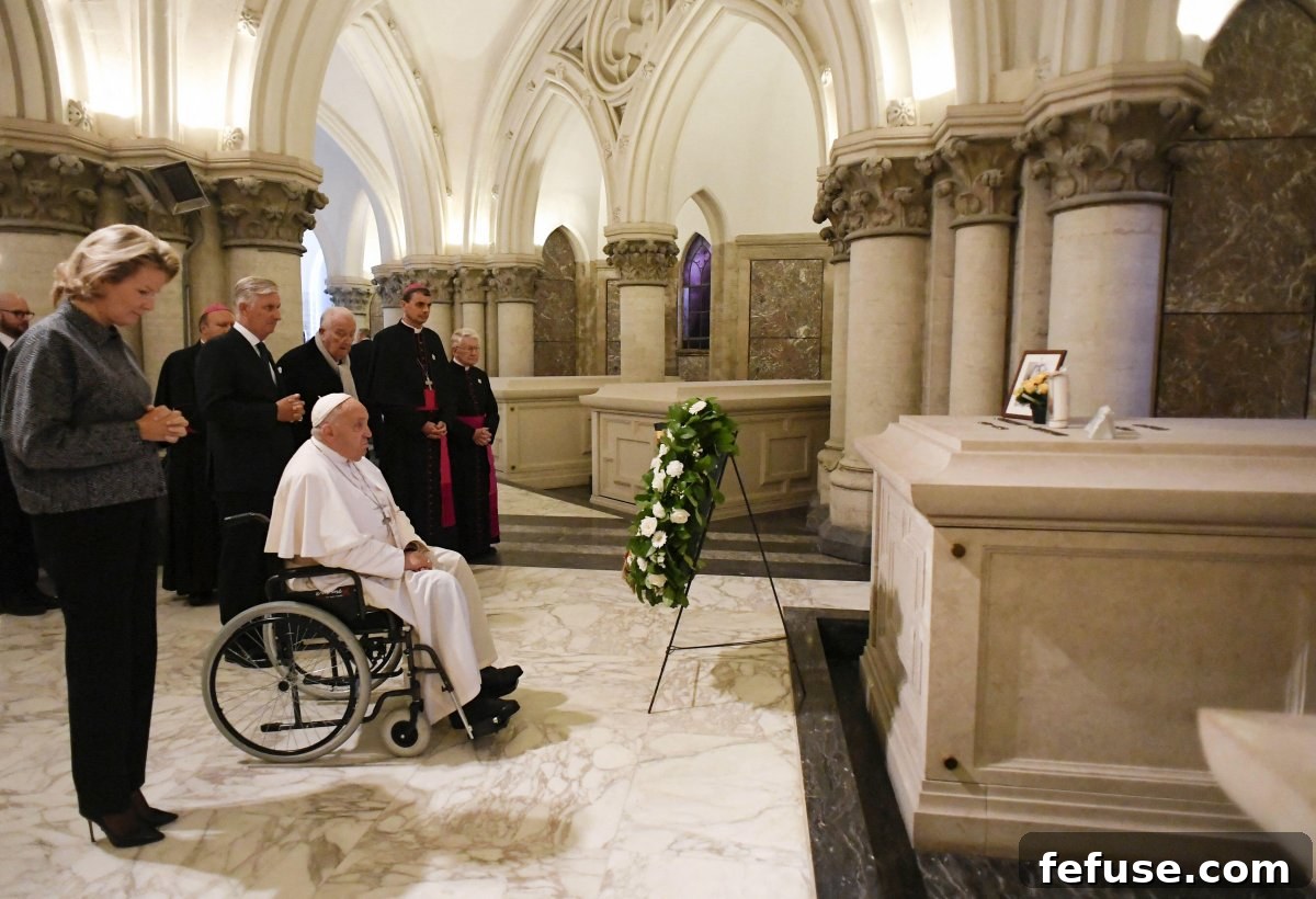 Pope Francis prays with the King and Queen of the Belgians before the tomb of King Baudouin in the royal crypt at the Church of Our Lady of Laeken on September 28, 2024 (Abaca Press/Alamy)