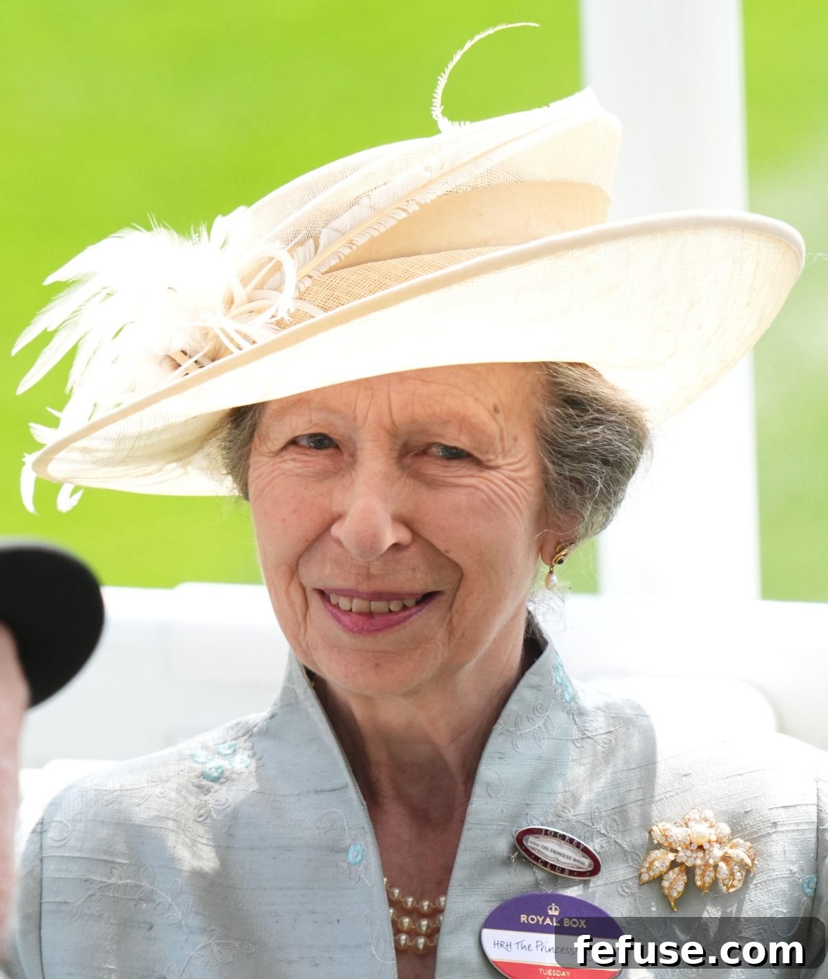 The Princess Royal, Princess Anne, attending Royal Ascot in a light blue and white outfit, featuring her signature floral brooch and Queen Elizabeth II's pearl necklace
